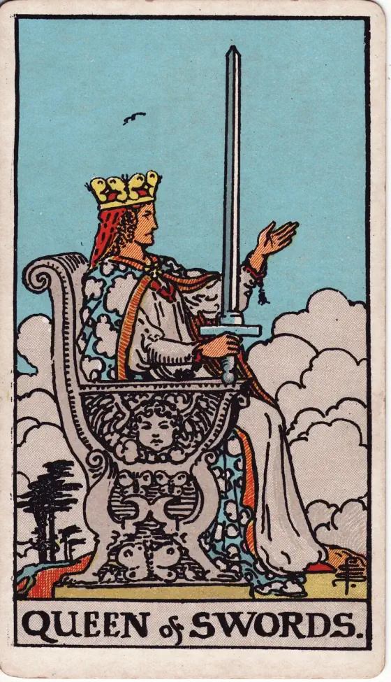 Queen of Swords: Her right hand raises the weapon vertically and the hilt rests on an arm of her royal chair; the left hand is extended, the arm raised.