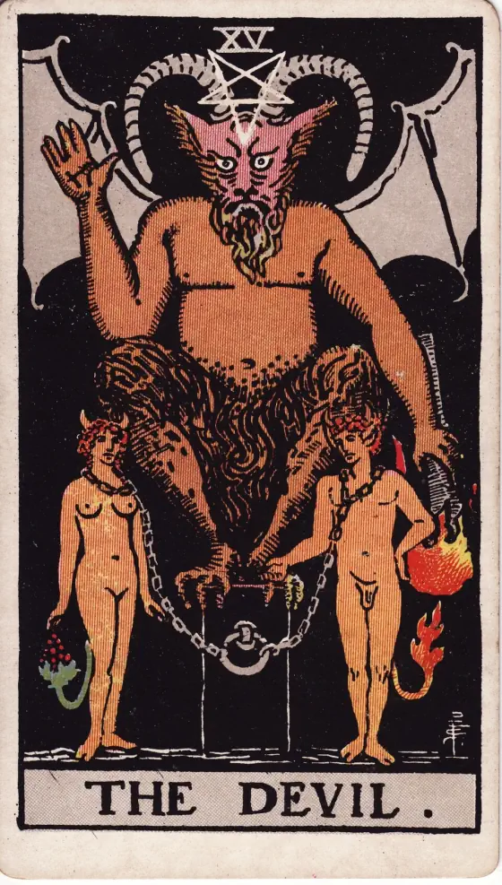 The Devil: A horned, bat-winged devil with an inverted pentagram above his head squats on a black block, one hand raised and the other holding a torch downward; a naked man and woman with horns and tails are chained by the neck to a ring on the block.