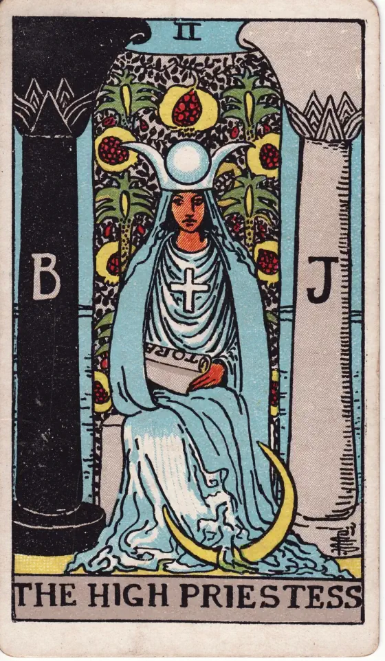 The High Priestess: She has the lunar crescent at her feet, a horned diadem on her head, with a globe in the middle place, and a large solar cross on her breast.