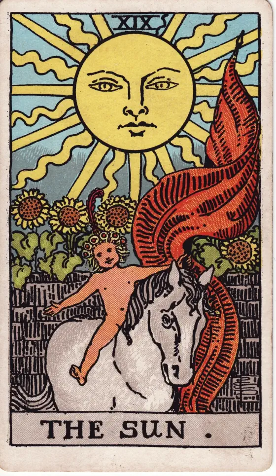 The Sun: A naked child on a white horse, carrying a long red banner, rides in front of a wall with sunflowers growing over it, under a great sun with a face.
